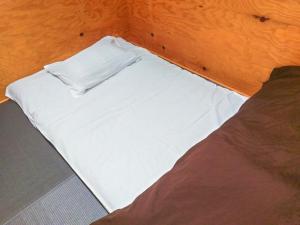 łóżko z białą pościelą i poduszką w obiekcie ゲストハウス高円寺純情ホテル -Guest House Koenji Junjo Hotel- w Tokio