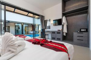 a bedroom with two beds with red bows on them at Thames Tara Private Pool Villa Rawai Phuket - SHA Extra Plus in Rawai Beach +76 photos