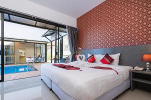 a bedroom with a large bed and a swimming pool at Thames Tara Pool Villa Rawai Phuket - SHA Extra Plus in Rawai Beach