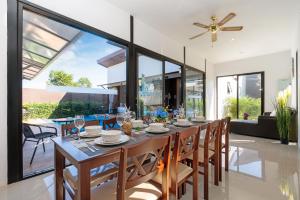 a dining room with a table and chairs and a ceiling fan at Thames Tara Private Pool Villa Rawai Phuket - SHA Extra Plus in Rawai Beach