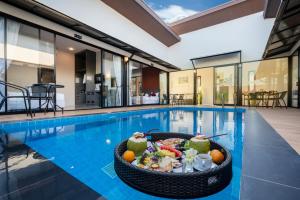 a pool with a bowl of food in the middle of it at Thames Tara Pool Villa Rawai Phuket - SHA Extra Plus in Rawai Beach