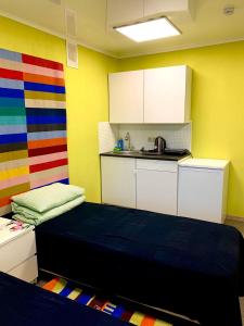 um quarto com uma cama e uma cozinha com paredes coloridas em Kakaduhome Guest Rooms em Khabarovsk