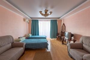 uma sala de estar com duas camas e um sofá em Kakaduhome Guest Rooms em Khabarovsk