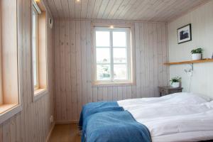 - une chambre avec un lit blanc et une fenêtre dans l'établissement Everts Sjöbods Bed & Breakfast, à Grebbestad