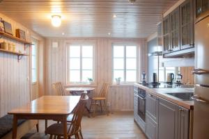 a kitchen with a table and a dining room at Everts Sjöbods Bed & Breakfast in Grebbestad