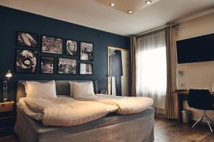 1 dormitorio con 1 cama grande y pared azul en Hotell Stadsparken, en Helsingborg