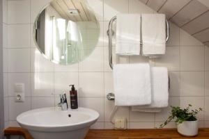 a bathroom with a sink and a mirror and towels at Everts Sjöbods Bed & Breakfast in Grebbestad