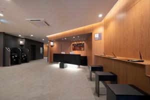 仙台市にあるR&B Hotel Sendai Higashiguchiのロビーにはデスクと椅子が備わる待合室があります。