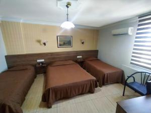 ein Zimmer mit zwei Betten und einem Tisch in der Unterkunft Yunus Hotel in Gaziantep