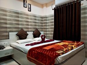 Un dormitorio con una cama con un par de zapatos. en Hotel Prince B en Guwahati