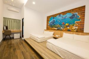 Un dormitorio con dos camas y un cuadro en la pared. en Xiaoliuqiu 88 Homestay, en Xiaoliuqiu