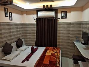 een slaapkamer met een bed met een gordijn en een televisie bij Hotel Prince B in Guwahati