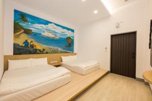 小琉球的住宿－小琉球八八民宿，一间设有两张床的客房,墙上挂着一幅画