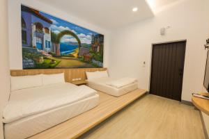 Una habitación con dos camas y un cuadro en la pared. en Xiaoliuqiu 88 Homestay, en Xiaoliuqiu