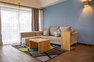 ein Wohnzimmer mit einem Sofa und einem Tisch in der Unterkunft Sports Road Apartments by Dunhill Serviced Apartments in Nairobi
