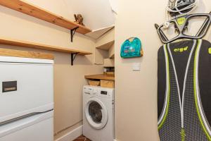 a small laundry room with a washer and dryer at Oxfordshire Living - The Bowler Hat Cottage - Woodstock in Woodstock