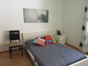 a bed with two pillows and a chair in a room at CAL41 in Calafat