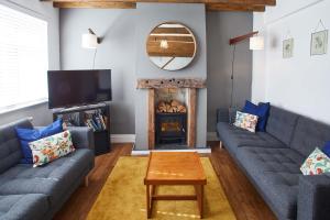 ein Wohnzimmer mit 2 blauen Sofas und einem Kamin in der Unterkunft Host & Stay - The Snug in Skelton