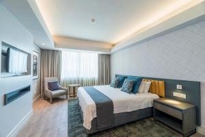 Habitación de hotel con cama y silla en Rainbow Towers Hotel & Conference Centre en Harare