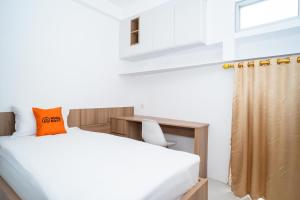 1 dormitorio con 1 cama con almohada naranja en KoolKost near University of Indonesia 2 - Minimum Stay 2 Nights en Pondoktjing Dua