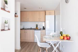 a kitchen with a table and a white refrigerator at matarolux18 in Mataró