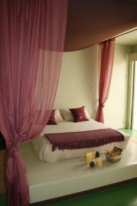 um quarto com uma cama grande e cortinas cor-de-rosa em Luz de Alba em Argamasilla de Alba