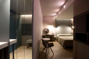 a room with a bed and a chair and a desk at Palace Hotel Moderno in Pordenone