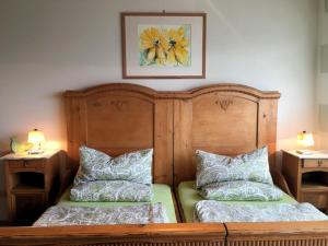a bedroom with two beds with pillows and a picture on the wall at Ferienwohnung Diesbrunnen in Ebermannstadt
