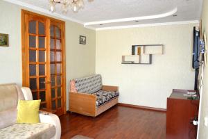a living room with a couch and a chair at Apartamenty na Prospekte Pobeda Revolutsii 99 in Shakhty