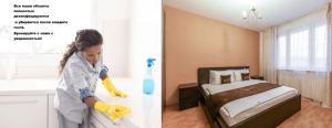 モスクワにあるInnDays on Belyaevo 91の女性がベッド付きのベッドルームを掃除しています