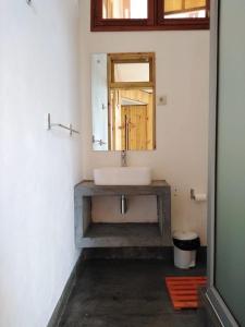 uma casa de banho com um lavatório e um espelho em Museu Mafalala B&B em Maputo