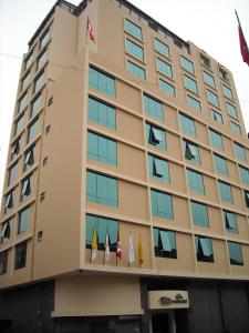 un bâtiment avec des drapeaux sur son côté dans l'établissement Hotel Continental Lima, à Lima