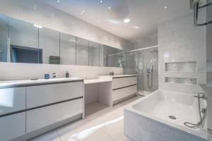 a white bathroom with a tub and a shower at Le Reflet du Lac in Annecy +31 photos