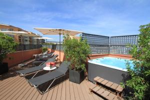 uma varanda com uma piscina e cadeiras e um guarda-sol em Garbi Millenni em Barcelona