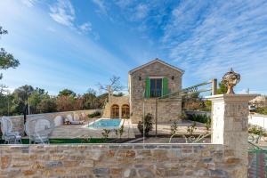 a villa with a swimming pool and a stone wall at Villa Perina Biograd, something completely different in Biograd na Moru