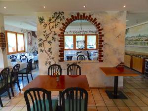 un ristorante con tavolo, sedie e muro di mattoni di Hotel Ahorni a Oberwald