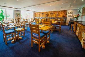 a restaurant with wooden tables and chairs and a brick wall at The Limes Country Lodge Hotel & Admiral Restaurant in Solihull