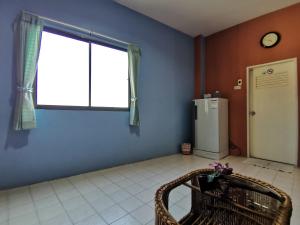 a room with a refrigerator and a window and a chair at Samran Residence in Krabi