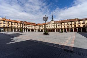 a large building with a clock tower in a courtyard at Housingleón - Albergue Turístico Nama Hostel in León
