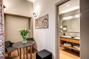 bagno con tavolo e vaso di fiori di Maison Ripetta a Roma