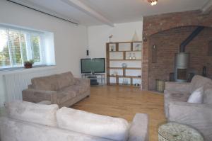 a living room with two couches and a television at Lakeside Old Hunstanton in Hunstanton