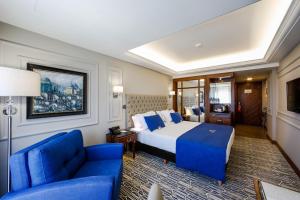 a hotel room with a bed and a blue couch at Gonluferah City Hotel in Bursa