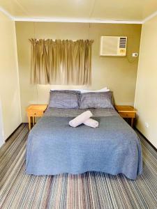 a bedroom with a bed with two towels on it at Riverside Hotel in Northam