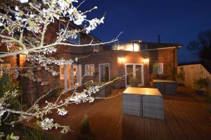 a brick house with a deck at night at Lakeside Old Hunstanton in Hunstanton