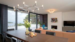 a dining room and living room with a table and a couch at Villa Eola Hvar in Jelsa