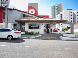 un coche blanco estacionado frente a un edificio en OYO Alto Da Praia Hotel, Aracaju, en Aracaju