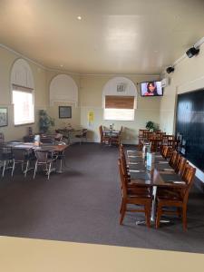 a dining room with tables and chairs and a flat screen tv at Riverside Hotel in Northam
