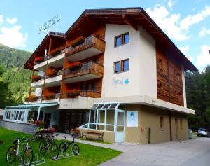 ein Gebäude mit Fahrrädern, die davor geparkt sind in der Unterkunft Hotel Ahorni in Oberwald