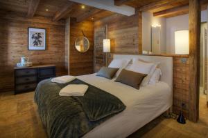 a bedroom with a large white bed with wooden walls at Chalet Goville - OVO Network in La Giettaz