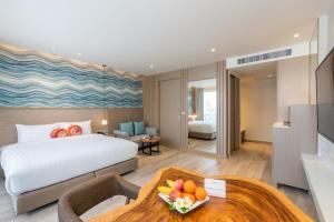 ホアヒンにあるMaven Stylish Hotel Hua Hinのベッドとテーブルが備わるホテルルームです。